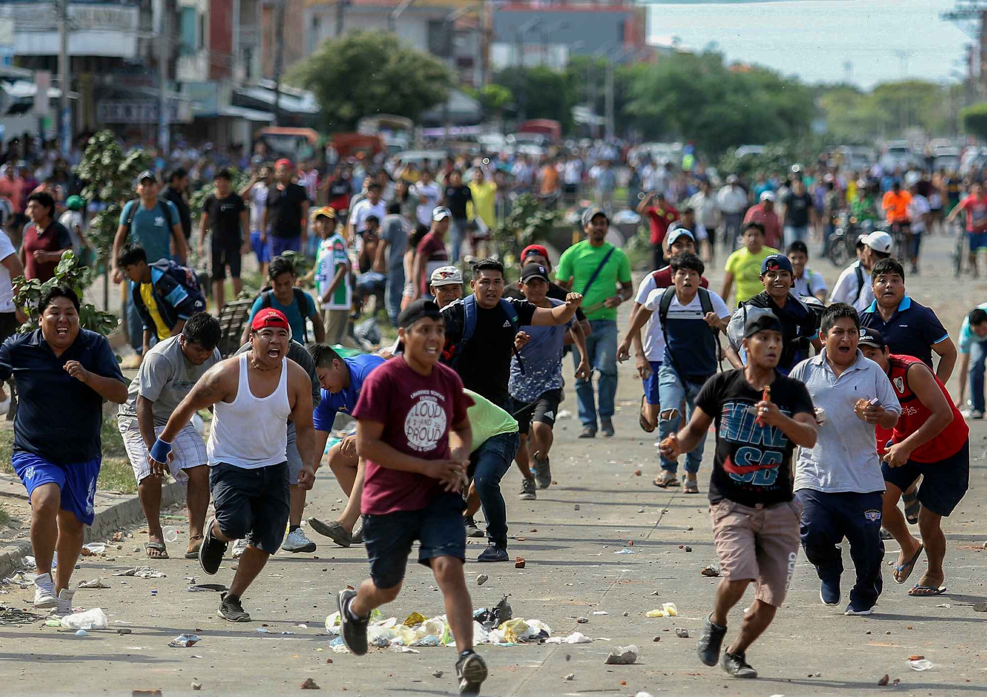 Los partidarios del candidato de la oposición boliviana Carlos Mesa y del presidente Evo Morales se enfrentan por los resultados elecorales en disputa, en Santa Cruz, Bolivia, el 23 de octubre de 2019.  La oposición de Bolivia lanzó una huelga general el miércoles en medio de protestas y disturbios por los resultados de las elecciones en las que Morales busca otro término. El presidente vinculó el paro con un golpe de la derecha. Foto por Daniel Walker / AFP.