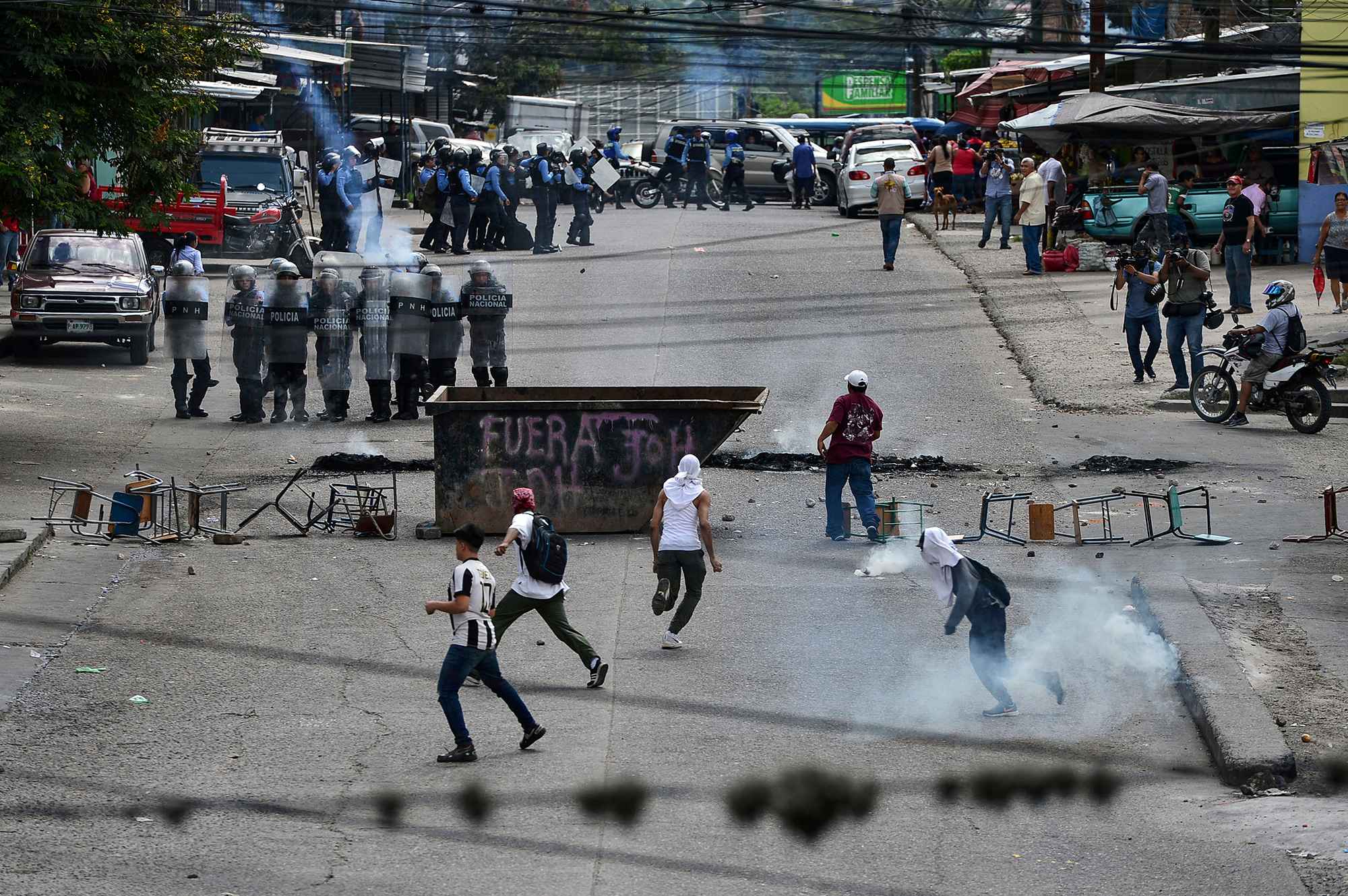 La policía antidisturbios hondureña se enfrenta a los manifestantes que exigen la renuncia del presidente Juan Orlando Hernández por sus presuntos vínculos con el narcotráfico. Tegucigalpa, 21 de octubre de 2019. Foto por Orlando Sierra / AFP.