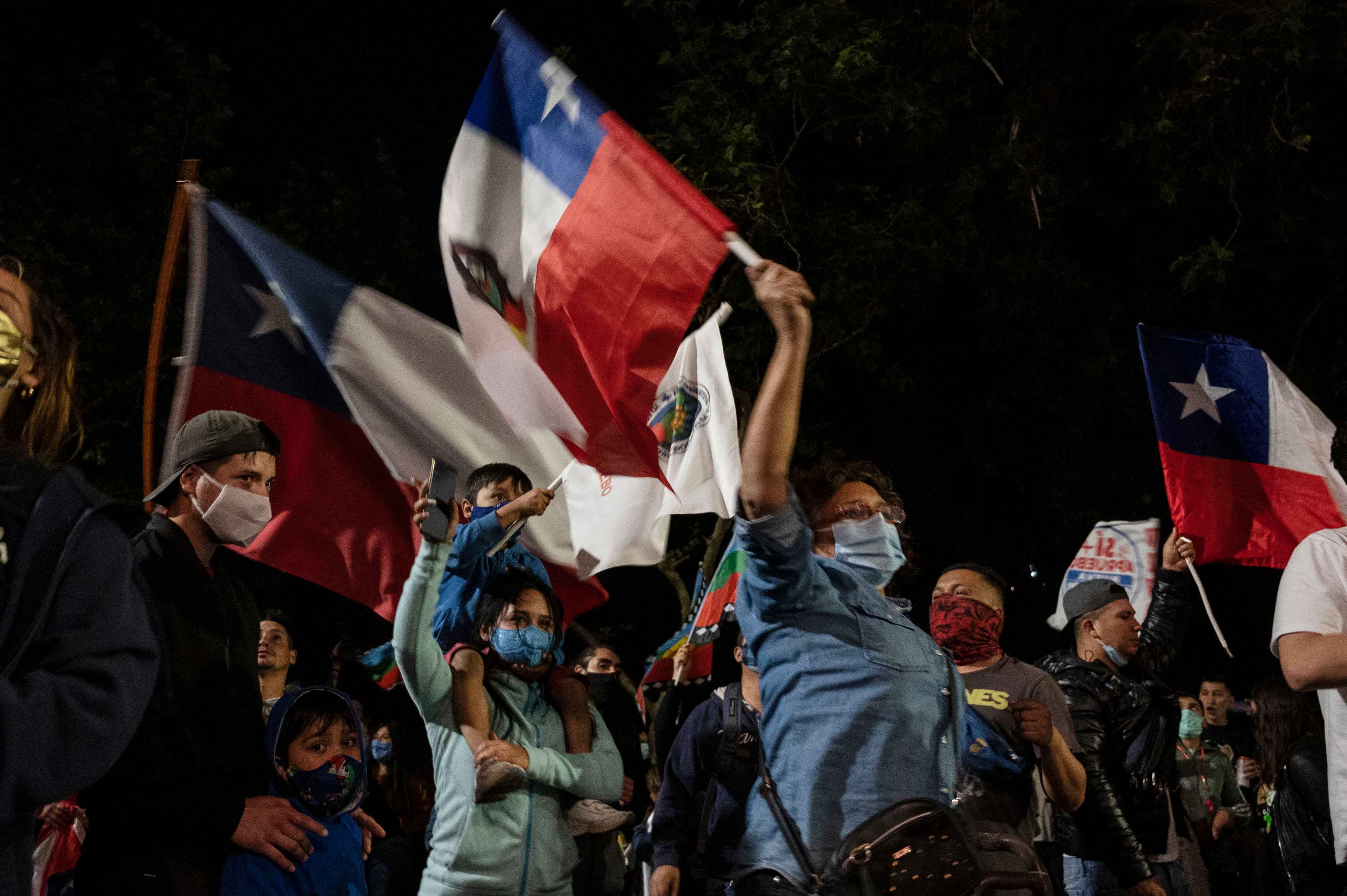 Demonstrators supporting the reform of the Chilean constitution celebrate while waiting for the referendum official results at Plaza Italia square in Santiago on October 25, 2020. - Chile's President Sebastian Pinera called on the nation to work together for a "new constitution" after Chileans voted overwhelmingly to replace their dictatorship-era charter. (Photo by Pedro Ugarte / AFP)