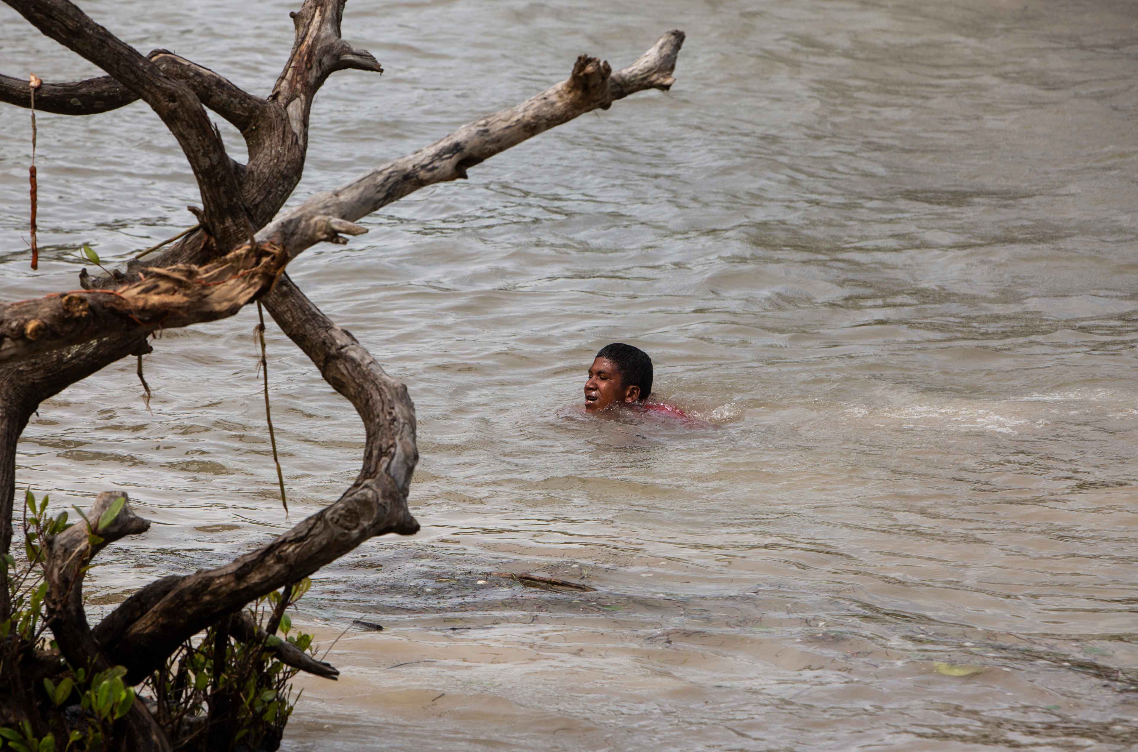 A man crosses a flooded area at "La Bocana" in Bilwi, Nicaragua on November 4, 2020, after the passage of hurricale Eta. - Hurricane Eta weakened to a tropical storm Wednesday as it pushed into Honduras, leaving behind a trail of destruction in Nicaragua where it made landfall the day before as a Category Four hurricane. (Photo by INTI OCON / AFP)
