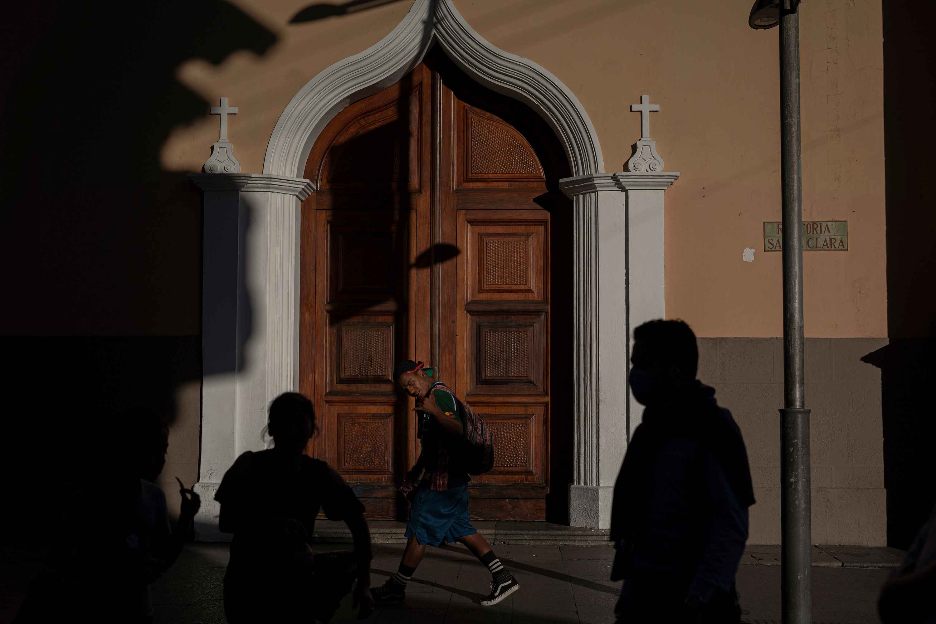 Yonaiker de Jesús Arévalo Ortiz, 20, strides down Sixth Avenue, the pedestrian walkway in the center of Guatemala City. Yonaiker is from Puerto Cabello, a city in the state of Carabobo, Venezuela. Like many Venezuelans in the city, he sells candy every day to buy a meal and find a place to sleep. Photo: Víctor Peña/El Faro