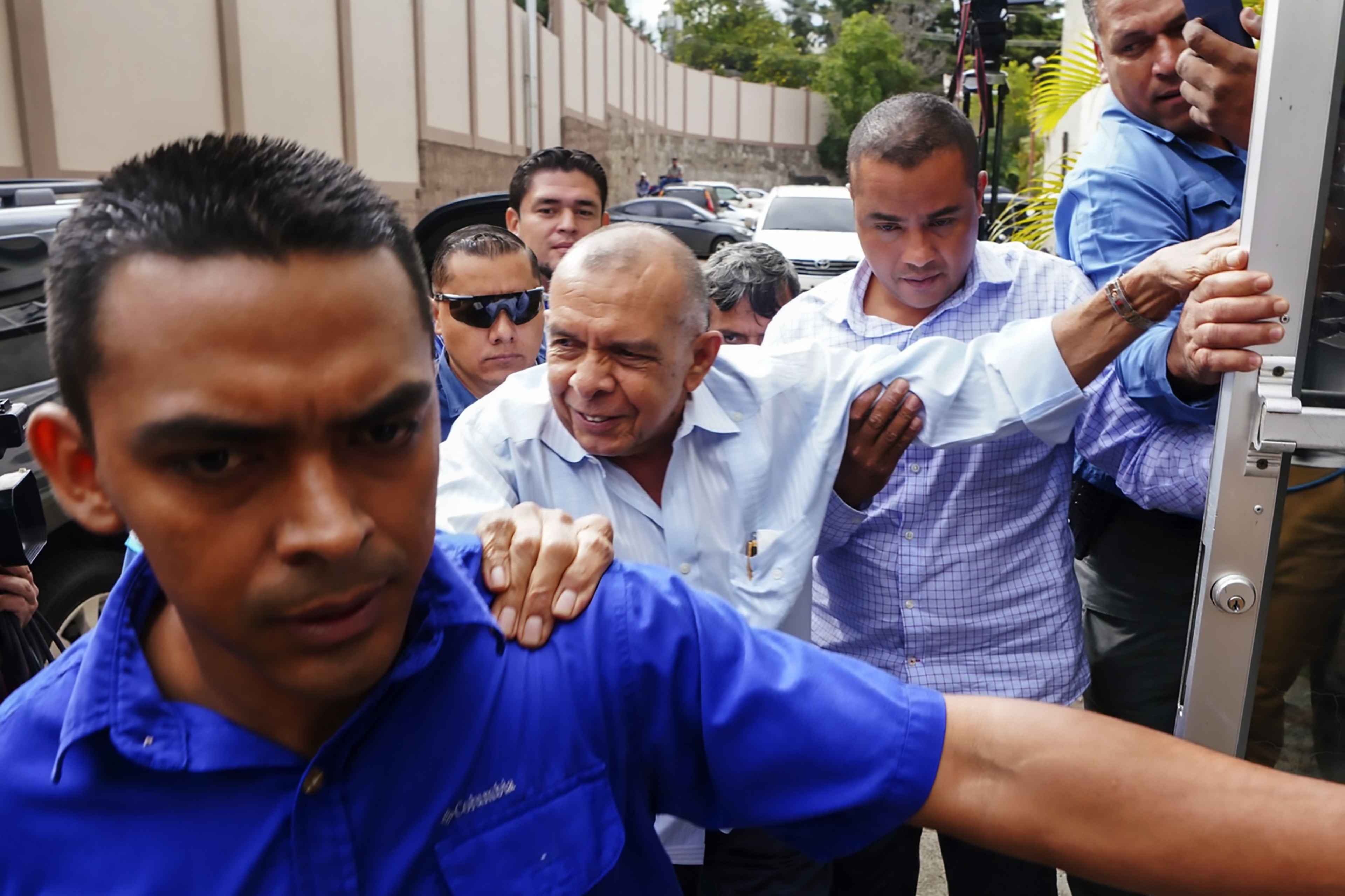 Porfirio "Pepe" Lobo (centro), expresidente de Honduras, a su llegada a un tribunal hondureño el 13 de abril de 2023 para enfrentar cargos por corrupción durante su gestión. En el caso, que aún espera juicio, está también acusado el expresidente Juan Orlando Hernández. Foto de El Faro: Johny Magallanes/AFP.