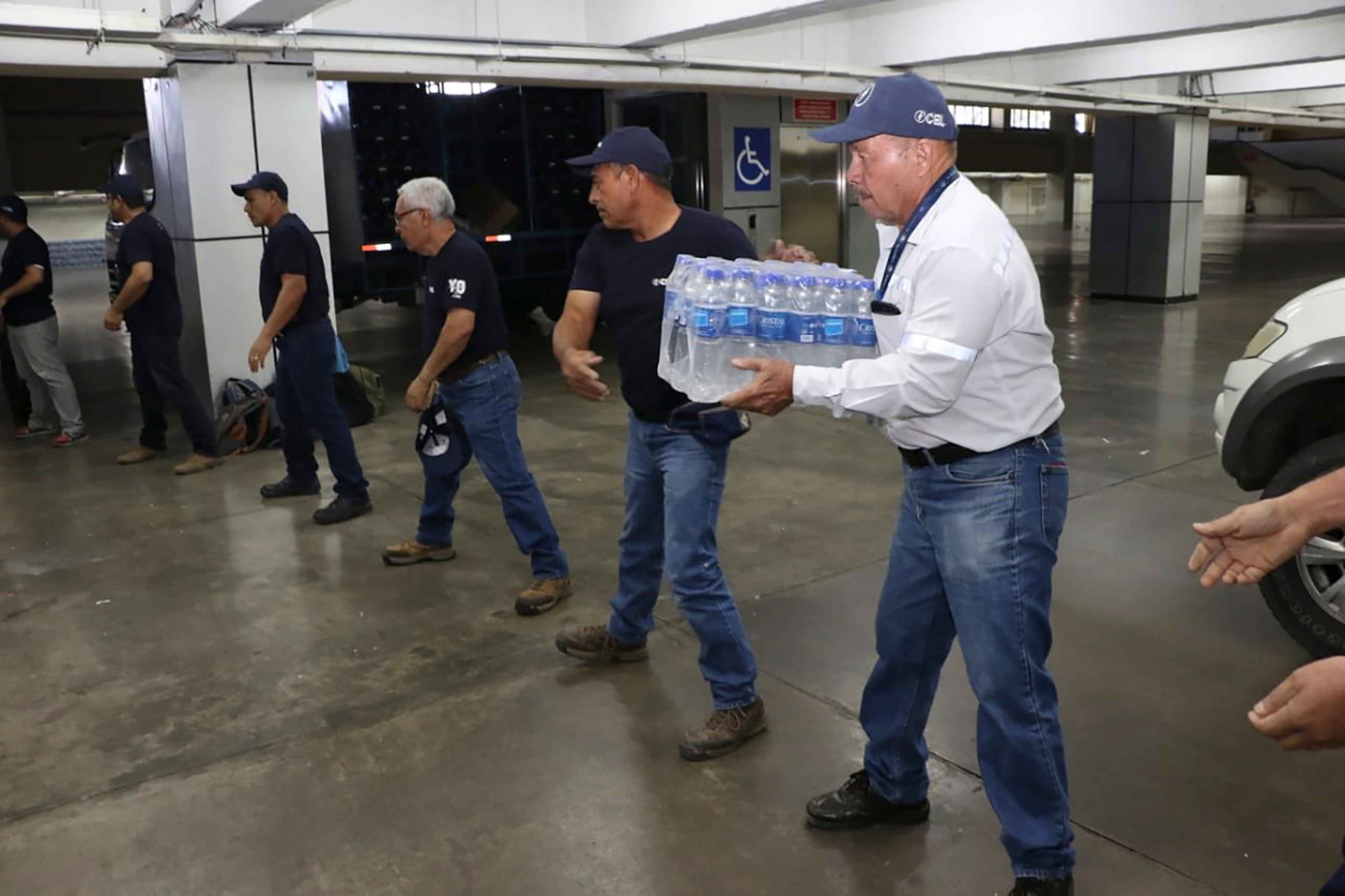 Government employees move packets of bottled water to be distributed in San Salvador during a potable water crisis in January 2020.