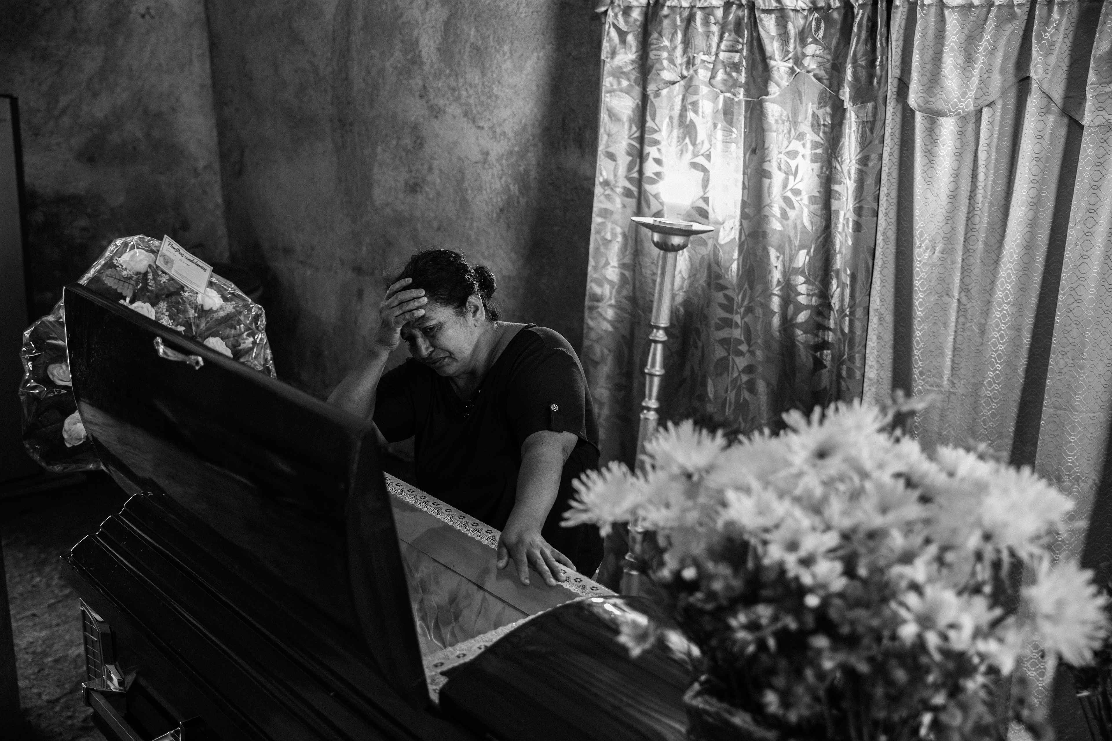 María Elena cries by her son's coffin. On Oct. 5, 2022, her son, Marvin Díaz, was captured in a rural area of Usulután. In prison, he fell ill due to the unsanitary conditions. On June 6, 2024, the court granted him his freedom after photographs of Marvin, chained to a hospital bed, went viral on social media. Marvin died on July 28, 2024, after not receiving adequate treatment in time.