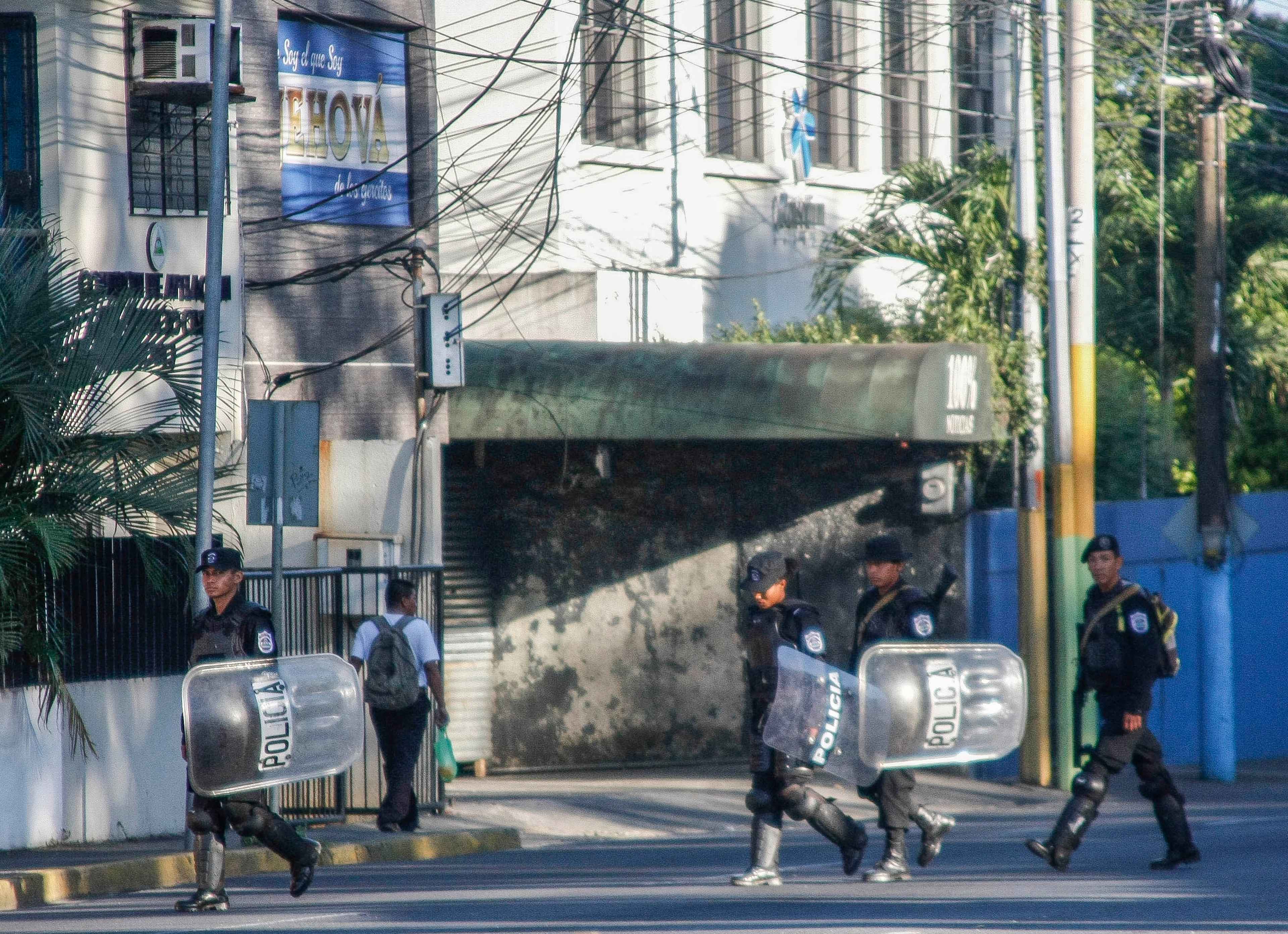 Riot police walk in front of the 100% Noticias televison station in Managua, on Dec. 22, 2018, a day after the station was raided and closed by the Nicaraguan Police. The director of 100% Noticias, Miguel Mora, was arrested in the raid. By then, rights groups reported that at least 320 people had been killed in a brutal government crackdown launched in response to the escalation in April of street protests, initially against pension reform. Photo Maynor Valenzuela/AFP